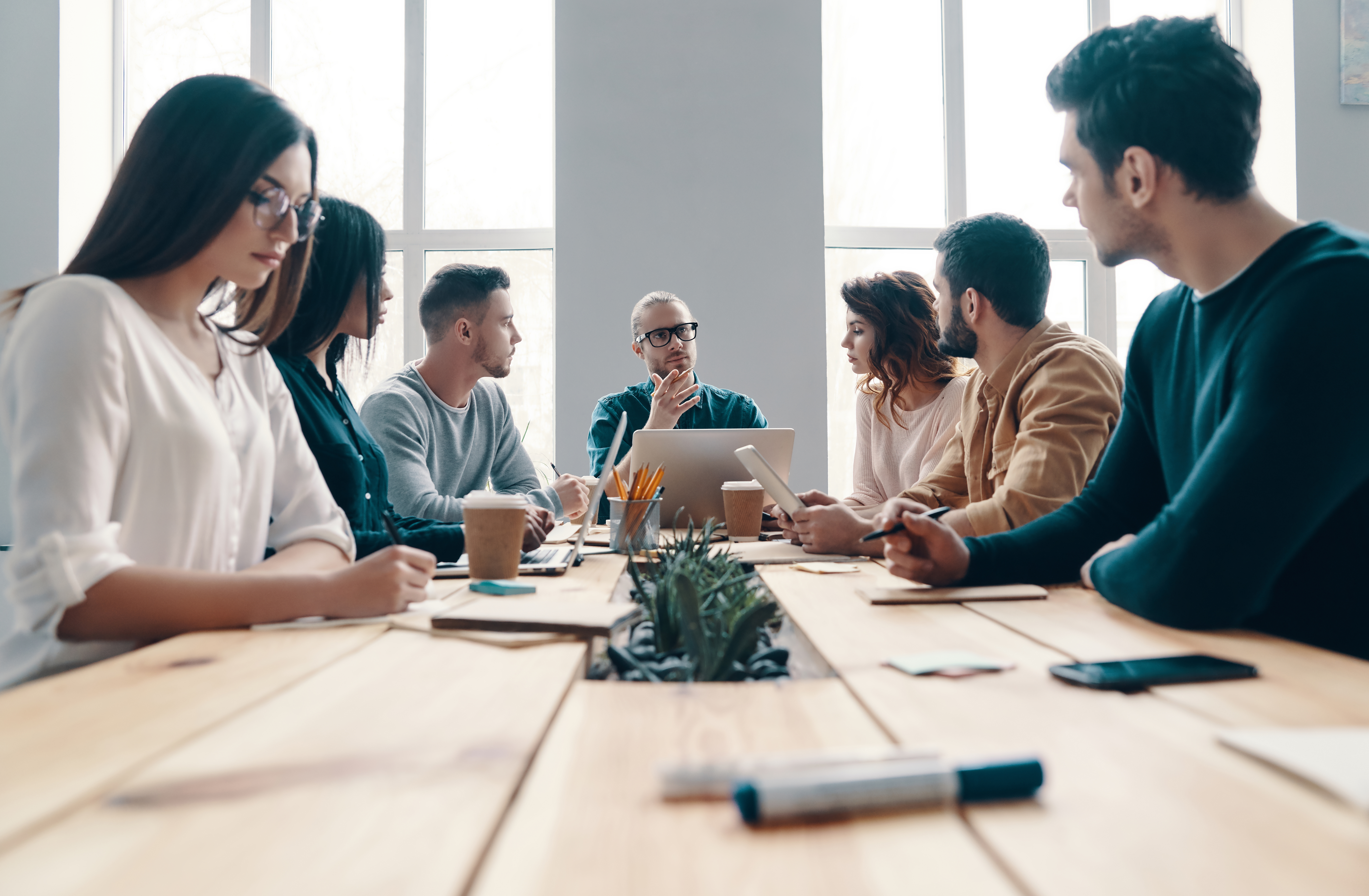 Group of professionals sitting and having a meeting about client campaigns