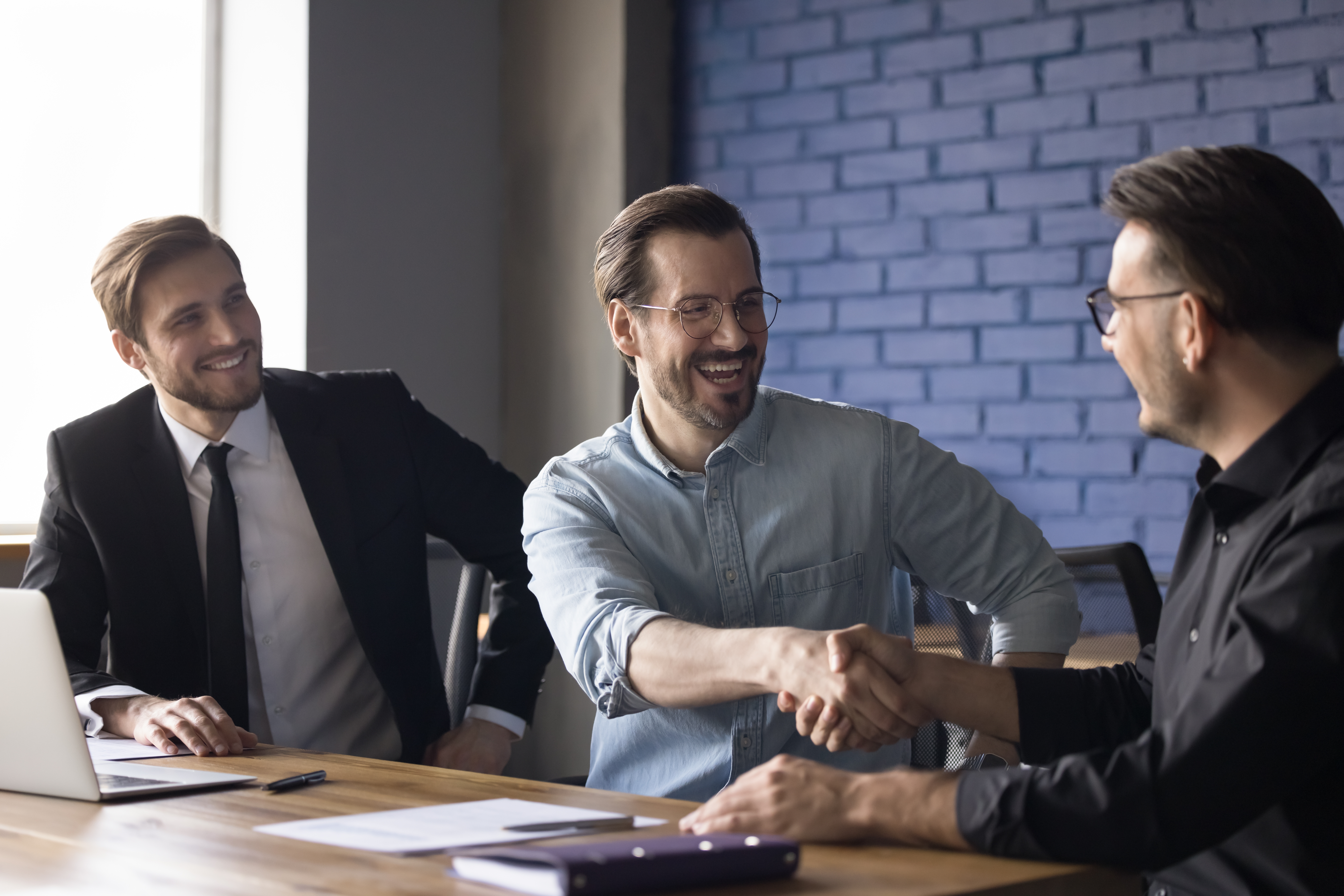Business professionals with strong product knowledge shaking hands with a client.